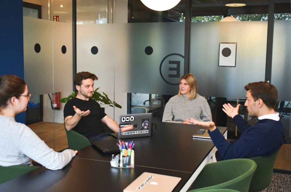 Krisenstab aus vier Personen berät in einem modernen Besprechungsraum