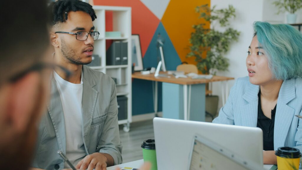 Junge Mitarbeiterin im Gespräch mit ihrem Vorgesetzten: Generation Z führen braucht Dialog