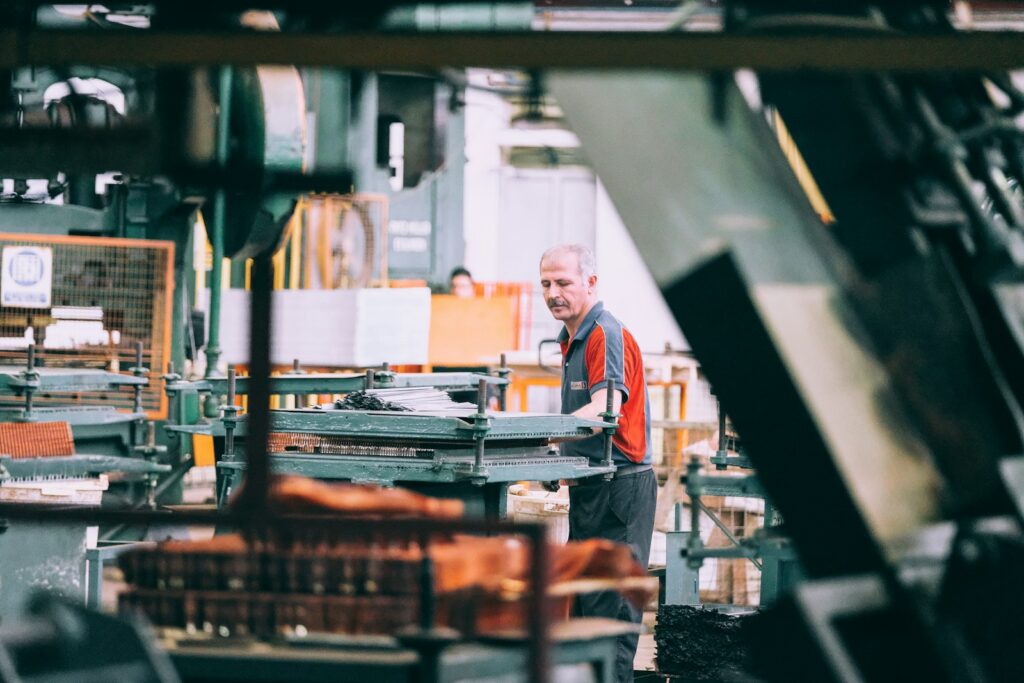 Facharbeiter bedient eine Industriemaschine: Hidden Champions setzen auf qualifizierte Mitarbeitende