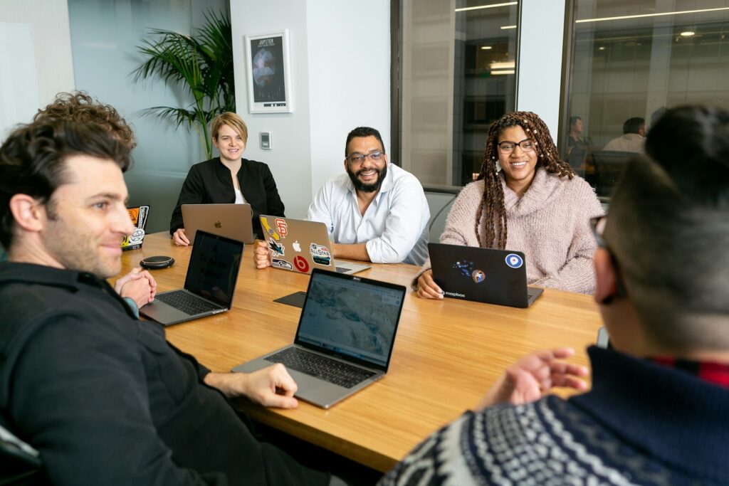 KI im Management: Führungsteam bespricht in einer Sitzung Ergebnisse an Laptops