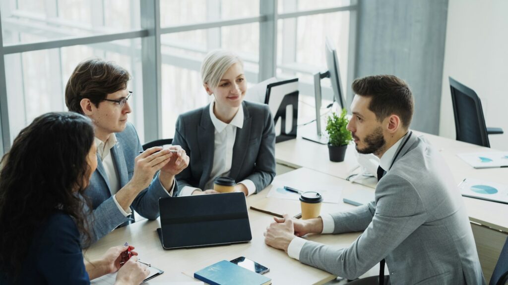 Vertriebsteam bespricht am Tisch die Kommunikation einer Preiserhöhung