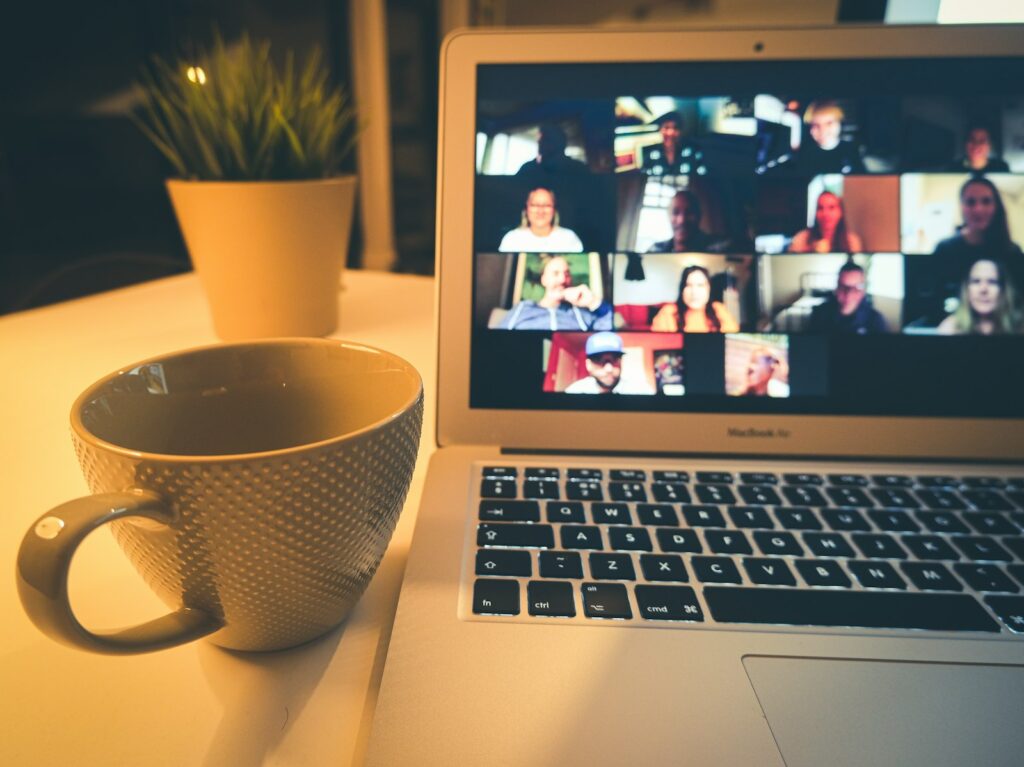 Laptop mit Videokonferenz vieler Teilnehmender: Remote-Teams führen mit klaren Kommunikationsregeln
