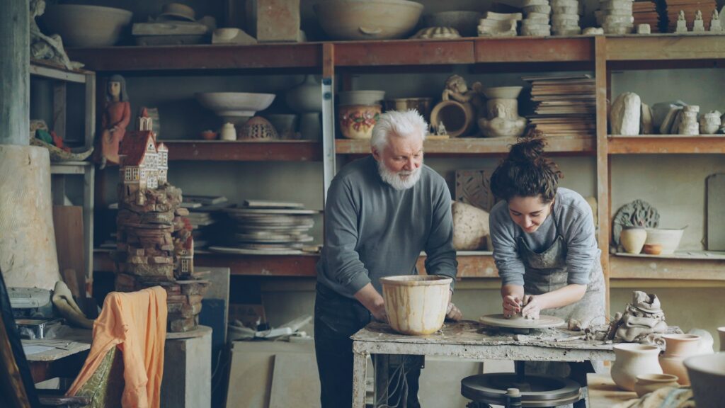 Meister und Nachfolger arbeiten gemeinsam in der Werkstatt: Unternehmensnachfolge im Familienbetrieb